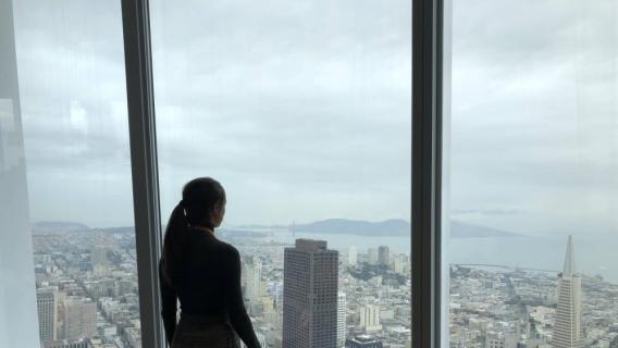 Student looking out the window of Salesforce Tower in San Francisco, California